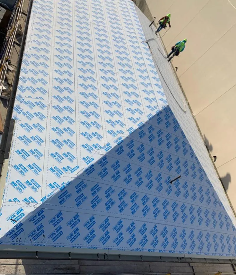 Professional roofers installing underlayment on a metal roof in Little Chute